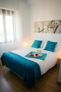 a bedroom with a large white bed with blue sheets at Holidays2Malaga Heredia 3 bedroom opposite Malaga Port in Málaga