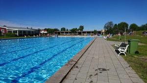 una gran piscina con 2 sillas al lado en Vännäs bad & camping, en Vännäs