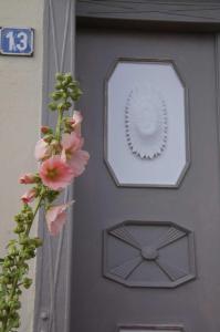 a grey door with a wreath and pink flowers at Am Hafen 13 in Glückstadt