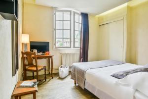 Rúm í herbergi á Hôtel Spa Mendi Alde