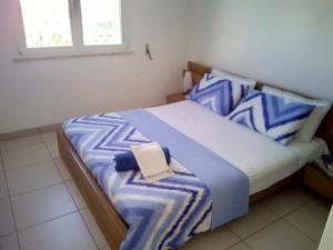 una camera da letto con un letto con cuscini blu e bianchi di Residence Sabbiachiara a Lido Marini