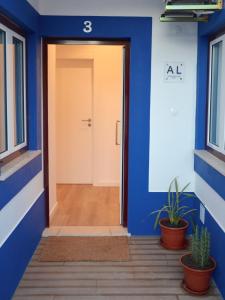 a door to a building with blue walls and plants at Solar do Alentejo in Cercal