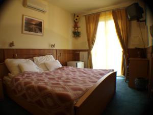 a bedroom with a bed and a large window at Galcsik Fogadó in Salgótarján