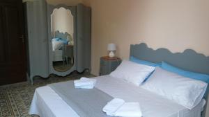 ein Schlafzimmer mit einem blauen und weißen Bett mit Handtüchern darauf in der Unterkunft Residenza 1930 in Castellammare del Golfo