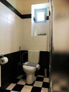 a bathroom with a toilet and a black and white checkered floor at Apollon Hotel in Chania