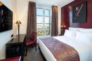 una camera d'albergo con letto, scrivania e finestra di Hotel Arok a Strasburgo
