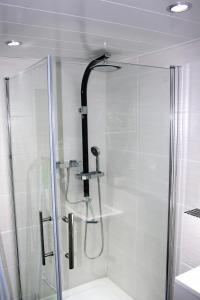 a shower stall with a glass door with a shower at Bungalow Thiele in Döbeln