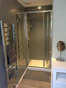 a shower with a glass door in a bathroom at Old Fisherman's Cottage in Rothesay