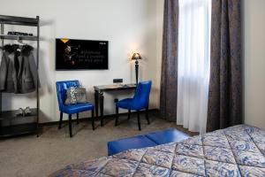 a hotel room with a bed and a desk and chairs at Hotel Arok in Strasbourg