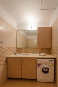 La salle de bains est pourvue d'un lavabo et d'un lave-linge. dans l'établissement Zakka's House, à Leonidio