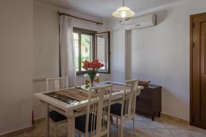 a dining room table with chairs and a vase of flowers at Zakka's House in Leonidio