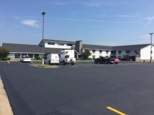 a parking lot with cars parked in front of a building at Regency Inn and Suites in Stilwell