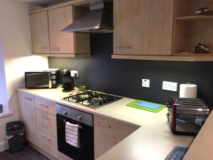 a kitchen with a stove and a microwave at Old Fisherman's Cottage in Rothesay