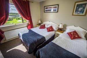 due letti in una camera d'albergo con finestra di Castle View House a Ballylongford