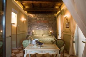 a bedroom with a bed with a table and chairs at Hotel Leon D'Oro in Orta San Giulio