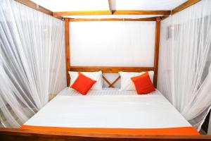 a bedroom with a bed with orange and white pillows at Villa Kandy with Private Pool in Kandy