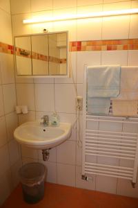 y baño con lavabo, espejo y toallas. en Hotel Alpenrose, en Bad Reichenhall