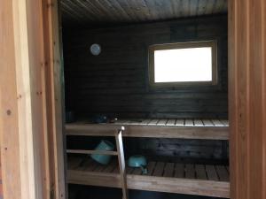 een kleine kamer met een raam in een houten hut bij ILO103 in Huhus