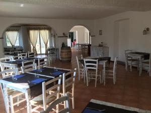 jadalnia ze stołami i krzesłami oraz kuchnia w obiekcie Albergo Ristorante Belcantone w mieście Novaggio