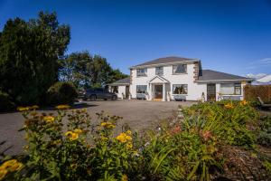 a house with a car parked in a driveway at Castle View House in Ballylongford