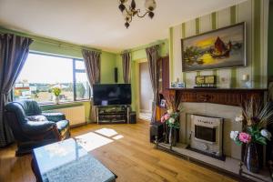 a living room with a fireplace and a television at Castle View House in Ballylongford