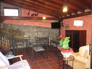 a living room with a table and chairs and a stone wall at Posada Campo in Suances +31 photos