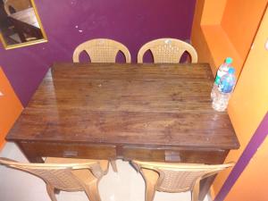 - une table en bois avec des chaises et 2 bouteilles d'eau dans l'établissement Four Seasons Home Stay (1BDH), à Madikeri 12 autres photos