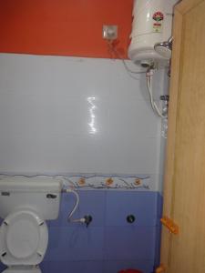 La salle de bains est pourvue de toilettes et d'un réservoir d'eau. dans l'établissement Four Seasons Home Stay (1BDH), à Madikeri