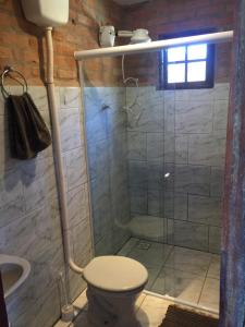 a bathroom with a shower with a toilet and a sink at Chalé Ibiti in Conceição da Ibitipoca