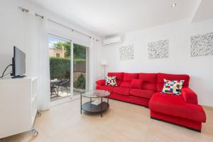 a living room with a red couch and a tv at Villa JERONIMO Alcudia in Muro