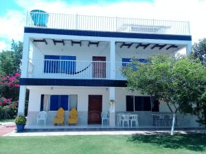 een wit huis met stoelen en een balkon bij Casa de Campo Palmarito in Tubará