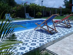 two lounge chairs sitting next to a swimming pool at Casa de Campo Palmarito in Tubará