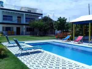 a swimming pool with two chairs and a house at Casa de Campo Palmarito in Tubará