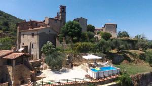 una casa antigua con piscina frente a ella en La Casetta Nel Bosco en Fosco