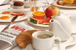 una mesa de desayuno con una taza de café y un cruasán en Hotel Ostmeier, en Bochum