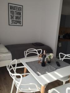 Biały stół i krzesła w pokoju z łóżkiem w obiekcie Apartament Fibra Cortado w Rybniku