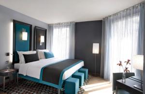 a bedroom with a large bed with blue accents at Hôtel Bassano in Paris