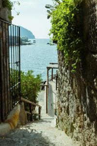 una pared de piedra con una puerta junto al océano en Hotel Umberto A Mare, en Isquia