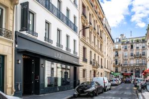a city street with cars parked on the street at Laz' Hotel Spa Urbain Paris in Paris
