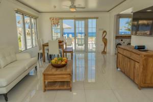 a living room with a couch and a bowl of fruit on a table at Stunning Ocean View in Negril