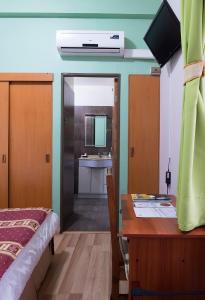 Schlafzimmer mit einem Bett, einem Schreibtisch und einem Waschbecken in der Unterkunft Hotel Samaña in Arica