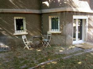 two chairs and a table in front of a building at 7 Rue du Docteur Paul Jouve in Digne-les-Bains