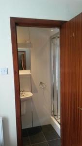 ein Bad mit einer Dusche, einem Waschbecken und einem Spiegel in der Unterkunft Beeches Guest House in Dyce