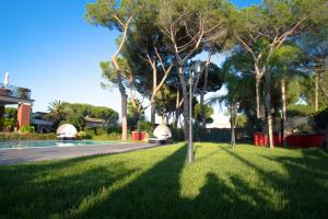 Relais Villa Italia في Selcetta: عشب اخضر به اشجار ومسبح