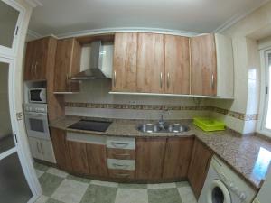 a kitchen with wooden cabinets and a sink at ALTILLO 25 GARAJE Y WIFI GRATIS in Córdoba
