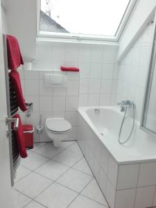 ein weißes Bad mit einem WC und einem Waschbecken in der Unterkunft Ferienwohnung Kreuder in Bergisch Gladbach