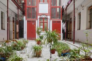 マドリードにあるLEEWAYS APARTMENT in DIVINO PASTORの赤い扉と鉢植えの古い建物