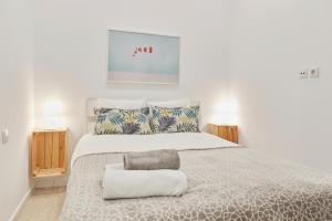 マドリードにあるLEEWAYS APARTMENT in DIVINO PASTORの白いベッドルーム(大型ベッド1台、ランプ2つ付)