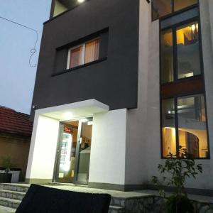 a black and white house with the door open at Guest House Vila Salute in Niš