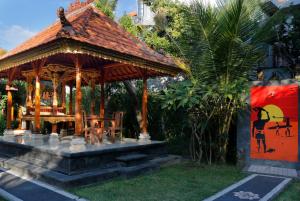 a gazebo with a table and chairs in a garden at Graha Madesimon in Ketewel